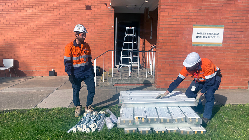 LED lighting ready for installation outside Tobruk Barracks with two Ventia employees