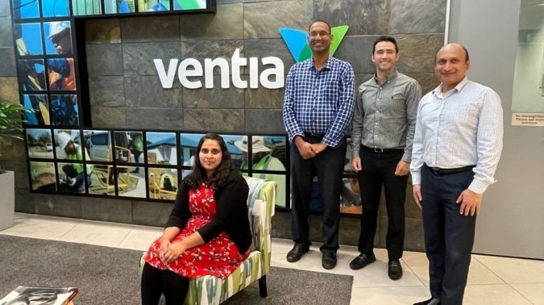 Spatial analysts gathered in front of a Ventia sign in 