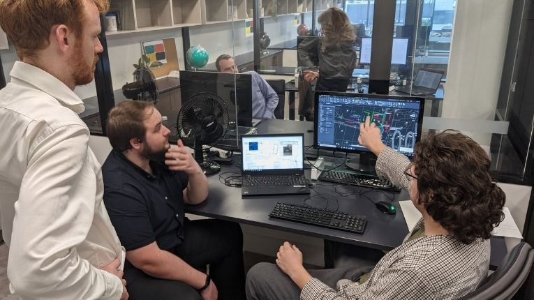 Spatial analysts gathered around a computer