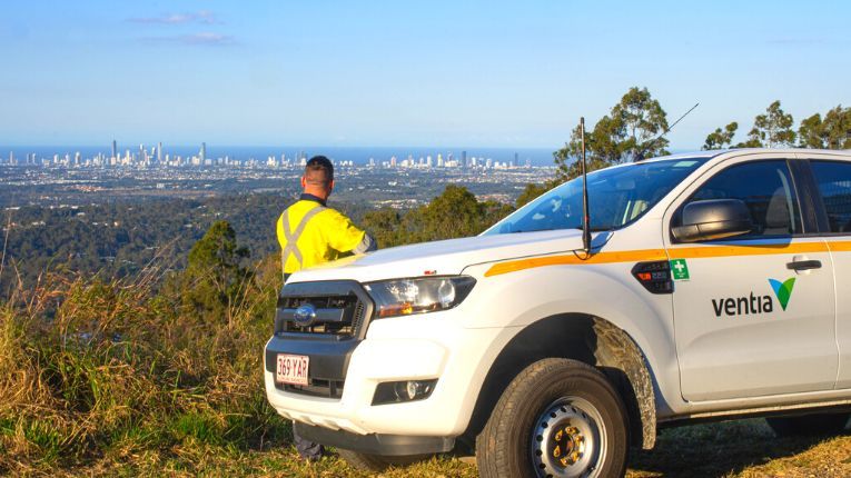 City view of Gold Coast with man and Ventia branded car 