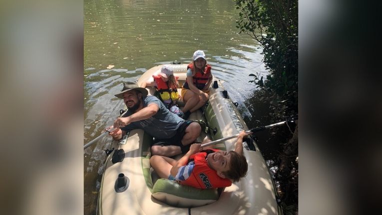 Jason McCallum in a boat with his three children 